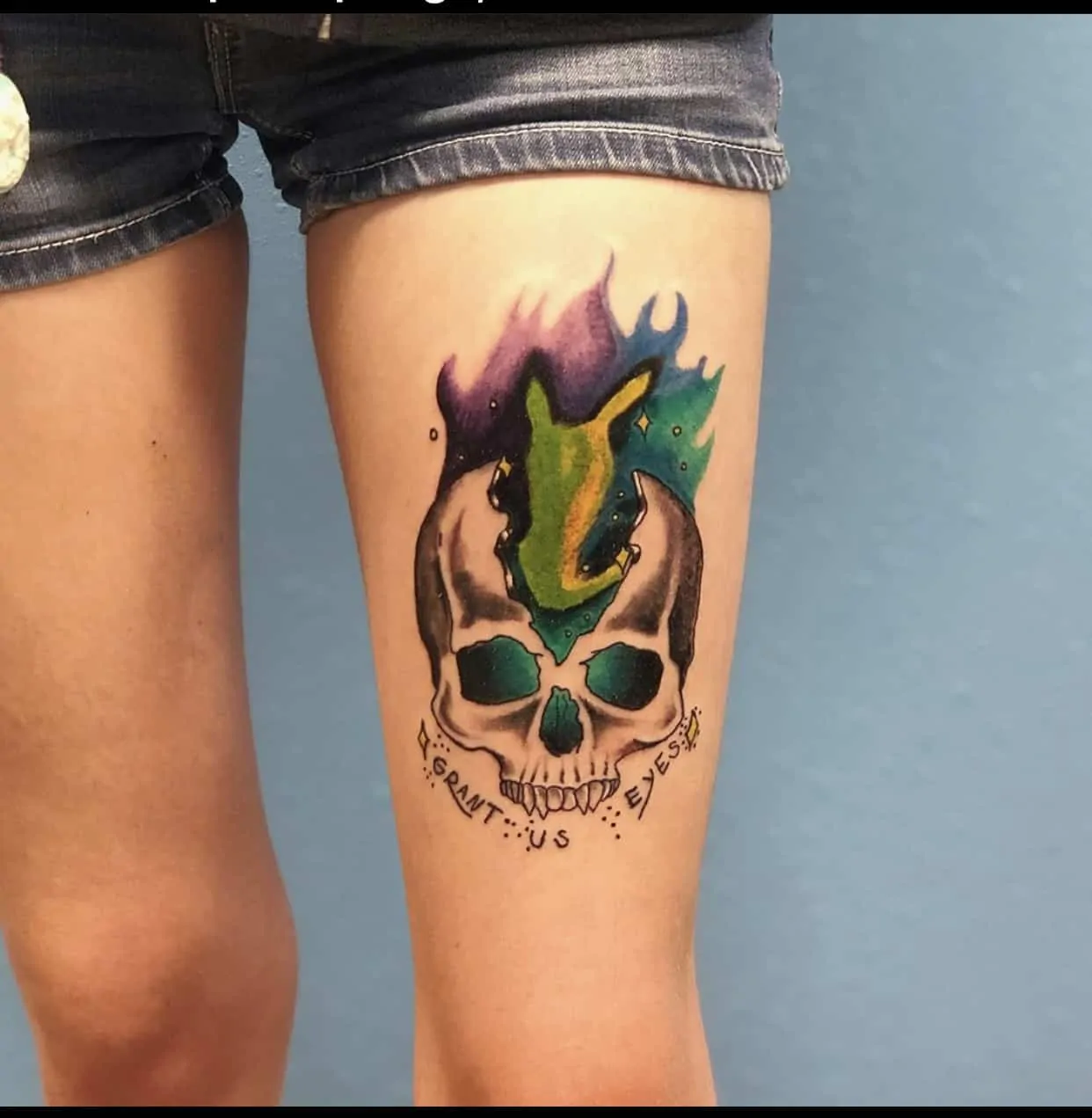 color flaming skull tattoo on thigh