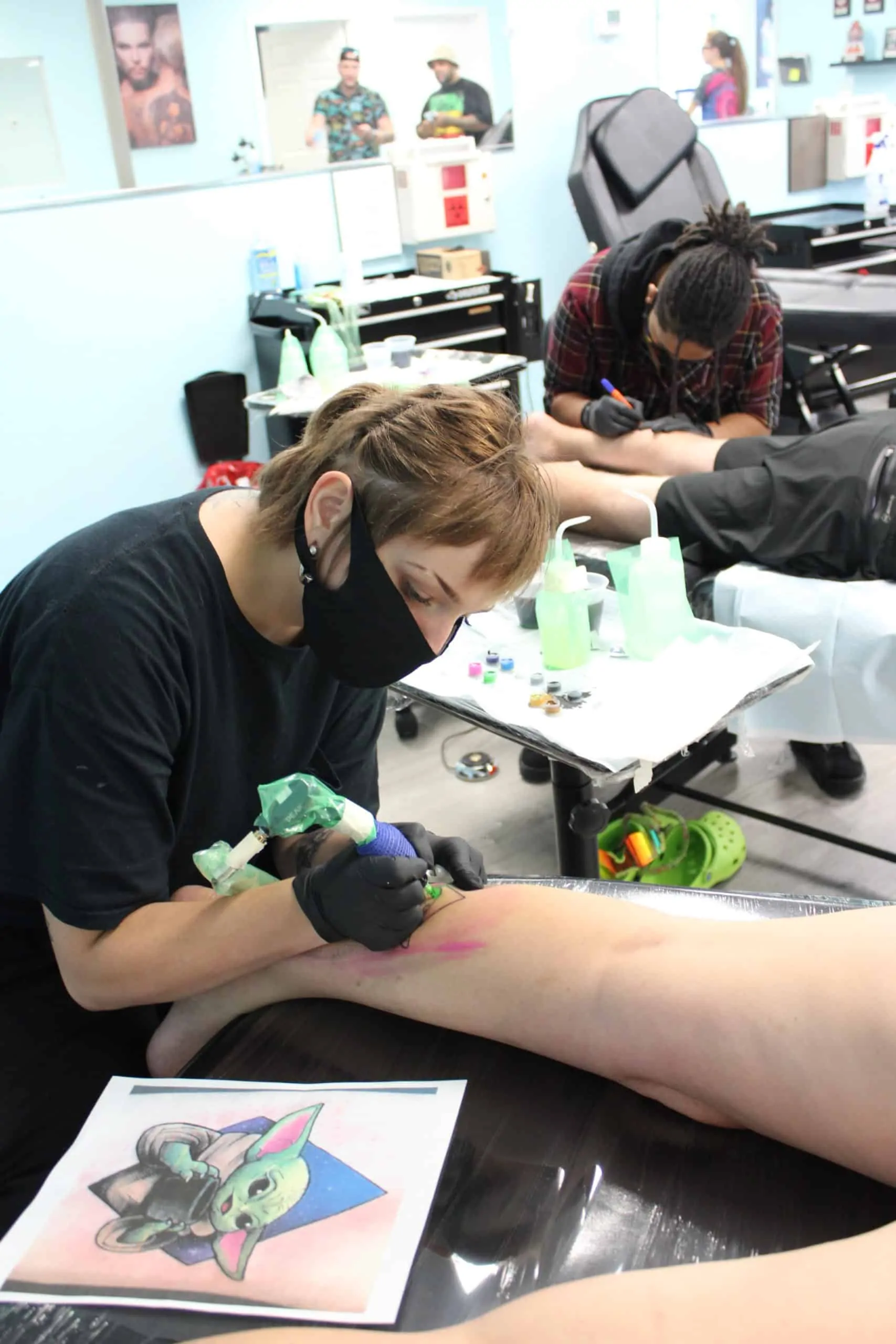 tattoo student working on tattooing calf