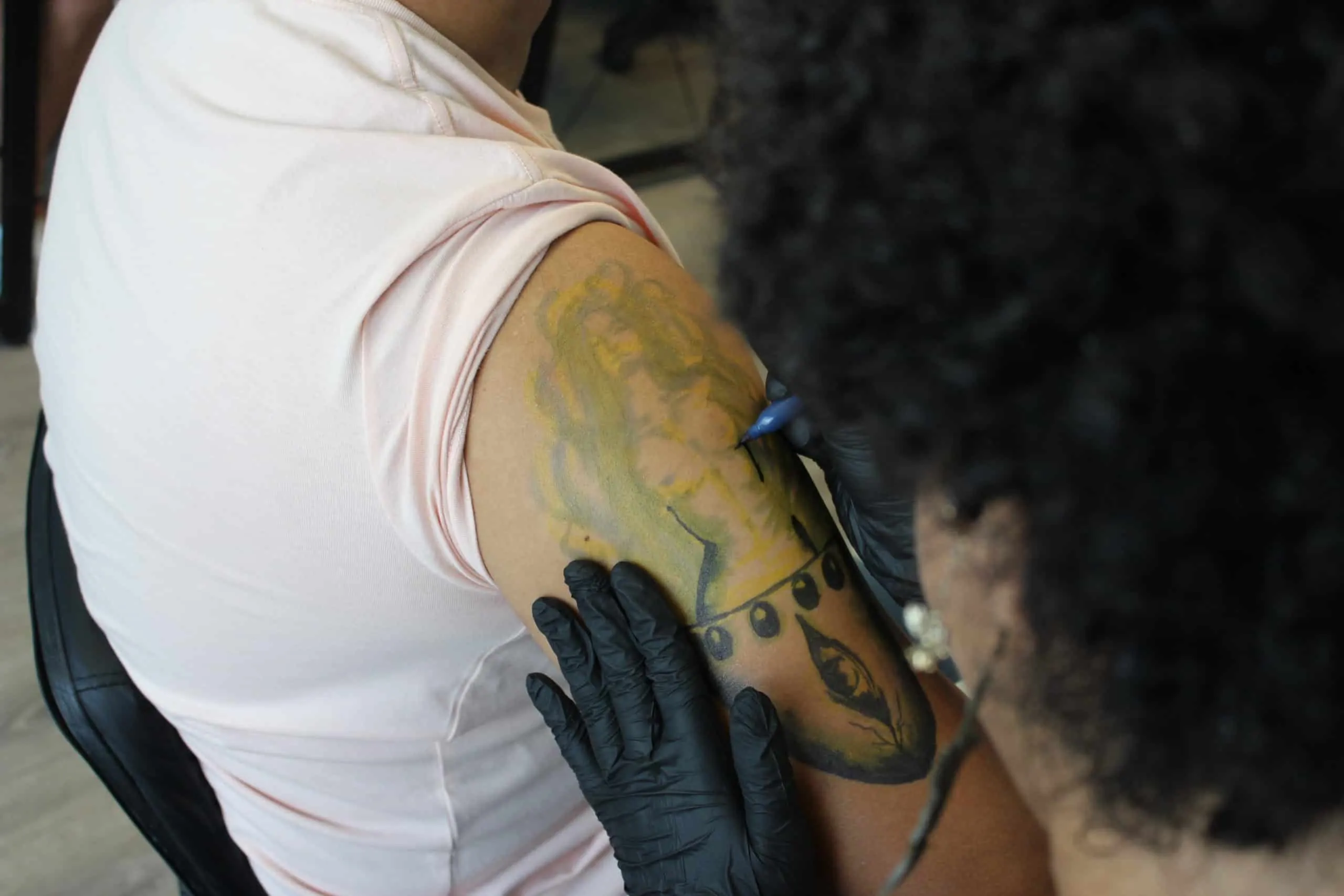 Tattoo artist sketching on arm