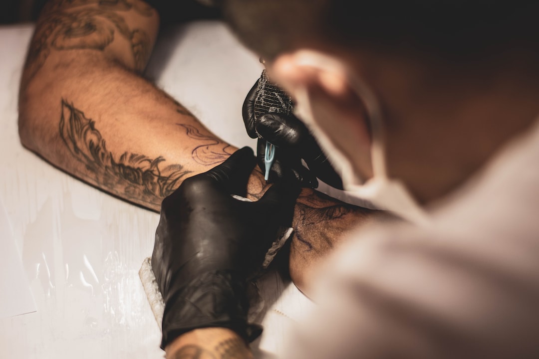 Cover up tattoo - a tattoo artist doing tattoo on the forearm.