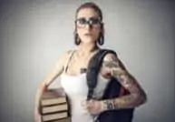 student with tattoos and books